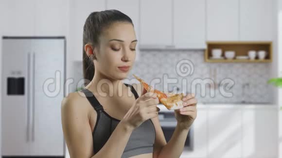 女孩正在家里厨房背景下吃披萨视频的预览图