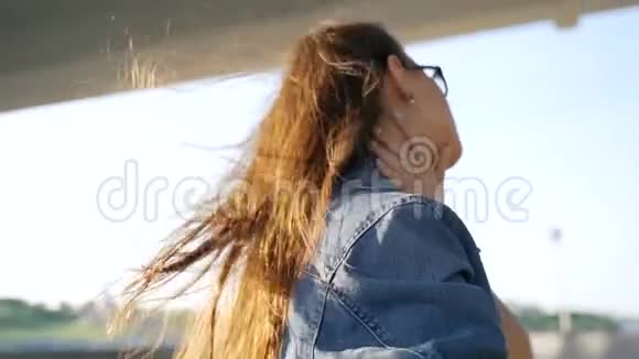戴眼镜的女孩在镜头前摆姿势在风中飘扬的头发在风中飘扬的头发视频的预览图