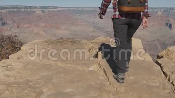 徒步旅行者活跃的女人走在大峡谷岩石边缘举起手臂视频的预览图