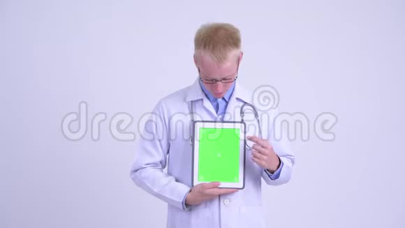 一位年轻的金发碧眼的医生在给我看数字平板电脑时解释视频的预览图