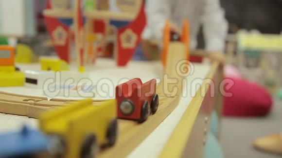 一个男孩在火车和一个孩子玩一个男孩在铁路上玩耍的手握着木制玩具火车视频的预览图