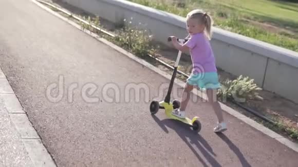 一个两条尾巴的小女孩正在公园里骑摩托车视频的预览图