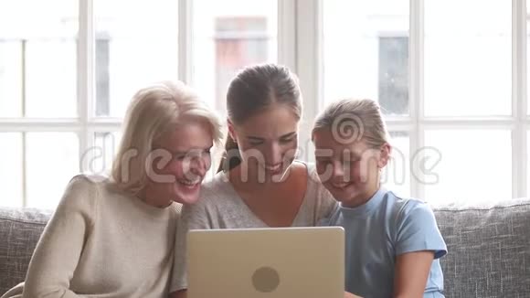 快乐的三女一代家庭看手提电脑卡通视频的预览图