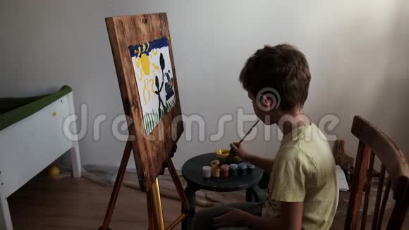学龄前儿童用画笔在画架上涂上水粉颜料视频的预览图