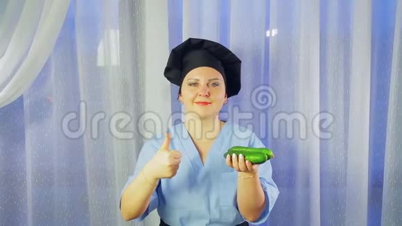 女厨师穿着围裙微笑手里拿着黄瓜展示全班同学视频的预览图