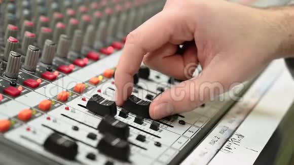 特写混合控制台声音总监手动调整着色器专业录音室在工作中视频的预览图