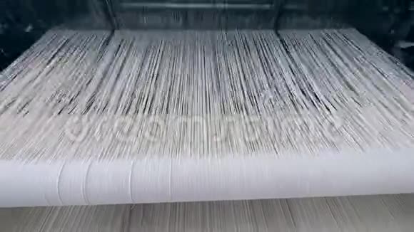 织布机在一家纺织厂与白色织物一起工作纺织厂设备在工作视频的预览图