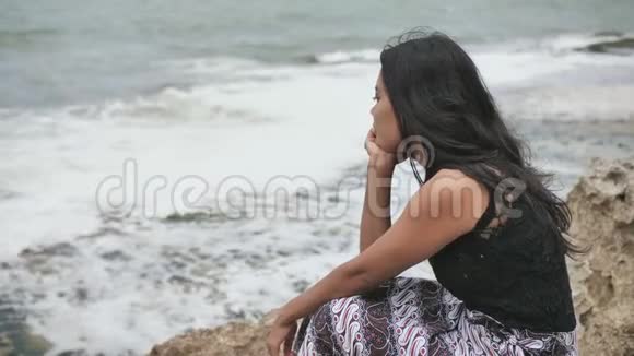 印度尼西亚女孩在巴厘岛的岩石海岸上悲伤视频的预览图