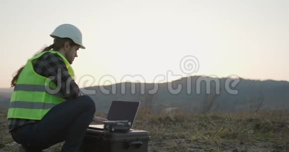 头盔里的工程师带着笔记本电脑在工厂工作创造新技术发展生产视频的预览图