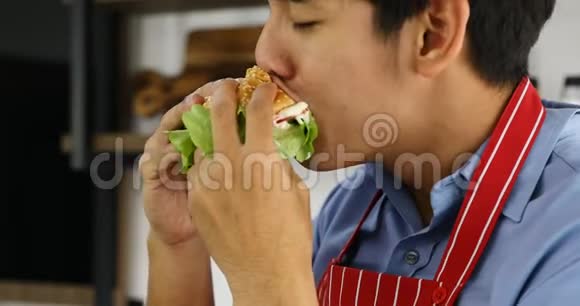 亚洲男人吃汉堡看起来很好吃视频的预览图