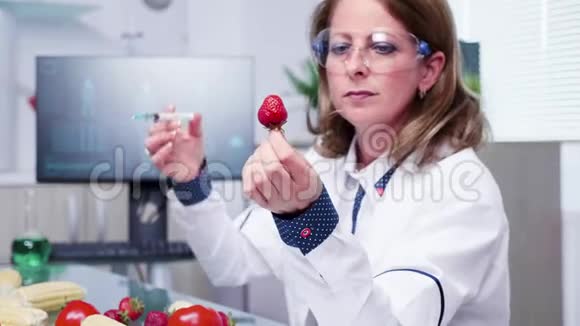 放大科学家在草莓中注射转基因样品的特写镜头视频的预览图