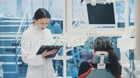 医生记录病人数据或病史去你的办公室看医生或牙医白色的视频的预览图