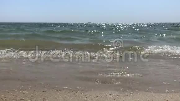 阳光明媚的海水和雄性成年腿被隔离在沙日落或日出海滩上的侧面景色视频的预览图