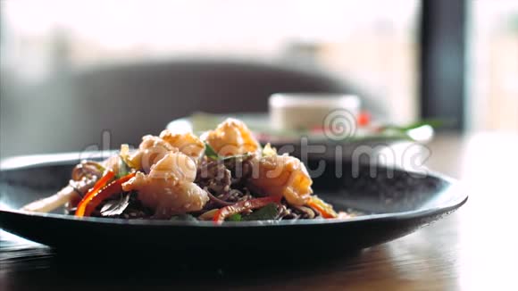 新鲜的青菜正落在传统的亚洲荞麦炒面和虾上视频的预览图