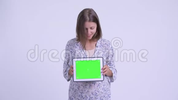年轻快乐的孕妇展示数码平板电脑看上去很惊讶视频的预览图