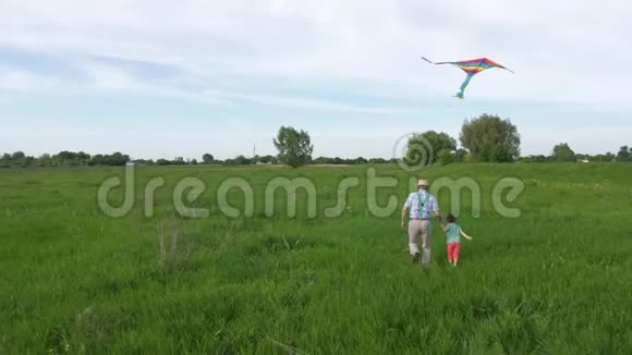 快乐的爷爷和孙子带着风筝跑步视频的预览图