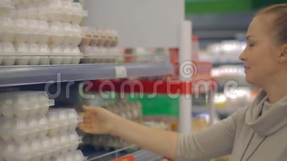 生活方式的女人在超市里选择鸡蛋视频的预览图
