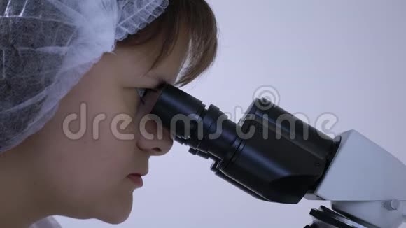 女化验员克劳瑟普盯着显微镜的目镜视频的预览图