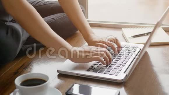 4K女人用手在笔记本电脑笔记本电脑键盘上打字以便在家里在地板上工作放松身心视频的预览图