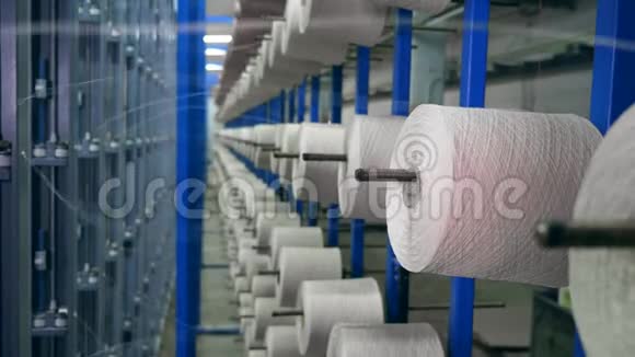 纺织厂设备在工作带螺纹的筒管在线轴上挂在金属架上视频的预览图