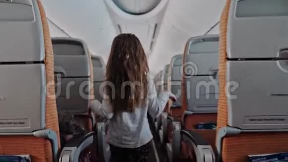 在机场里孩子们在机舱里散步可爱的小女孩走过道进入机舱视频的预览图