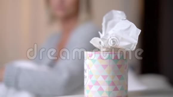 患有流感病毒的患病妇女在床上用鼻子打组织视频的预览图