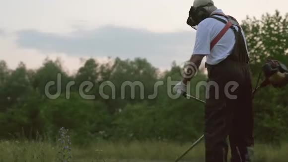 穿工作服戴防护面罩割草的男工视频的预览图