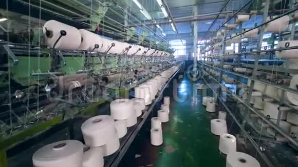 有工作机器的设备把线绕到线轴上纺织机在纺织物上工作的机器视频的预览图