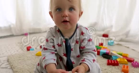 可爱有趣的小女孩穿着五颜六色的衬衫玩建筑玩具积木视频的预览图