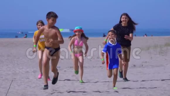 五个穿着鲜艳衣服的快乐孩子从海里跑出来视频的预览图