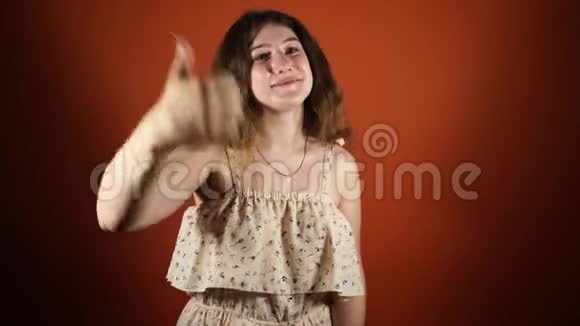 我喜欢女人在橙色的背景上竖起大拇指像个样子视频的预览图