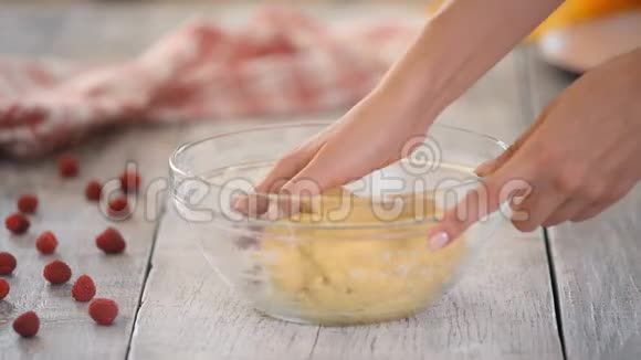 女性手揉面团女厨师在厨房桌子上的碗里混合配料视频的预览图
