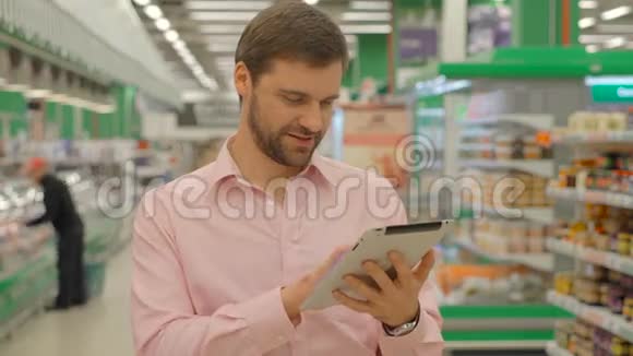 在超市商店里拿着平板电脑的人视频的预览图
