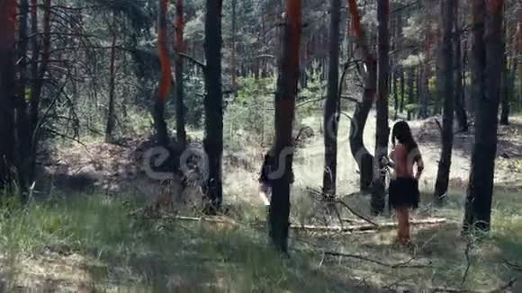 携带武器的野蛮猎人正在森林中的一块木头上踩4k视频的预览图