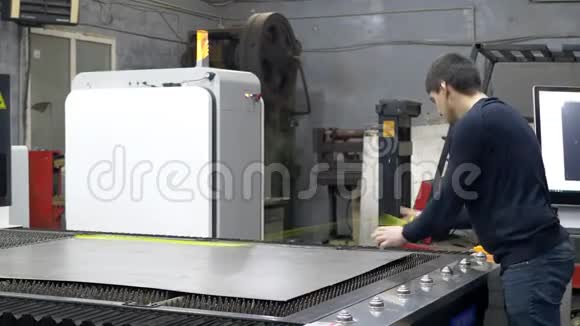 工程师在数控激光机床上调整切割金属板的铁片视频的预览图
