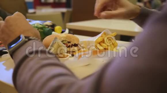 男人吃快餐特写汉堡和薯条视频的预览图
