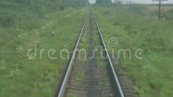 绿色草地和灌木背景下的铁路线路视频的预览图