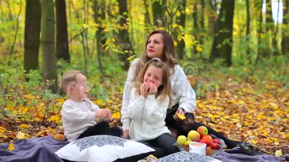 友好的家庭在秋天的森林里野餐视频的预览图