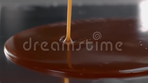 咸的融化焦糖被倒入厨房的金属表面用糖果制作慢慢烹饪甜点视频的预览图