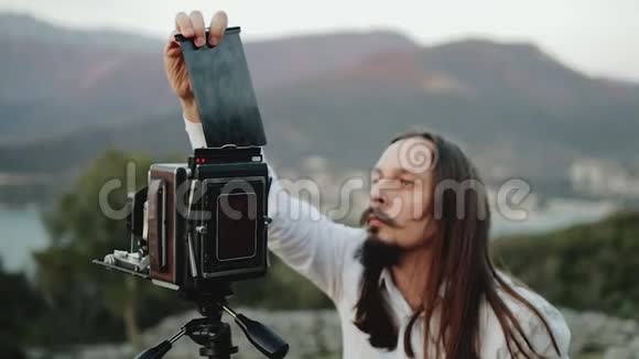 摄影师专业人员在大型相机上拍照视频的预览图