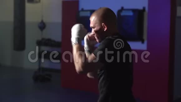 微光场景拳击手在健身房热身慢动作训练过程的侧面视图视频的预览图