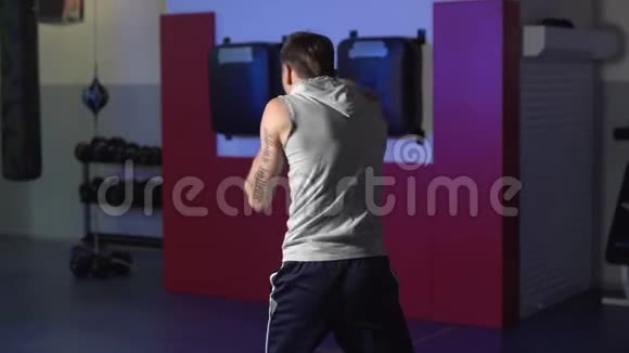 慢动作后景男拳击手训练在健身房影子战斗低灯光场景视频的预览图