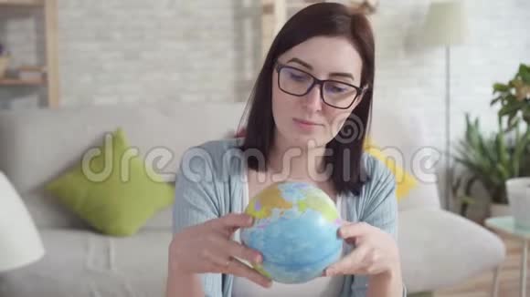 年轻女子检查一个地球仪视频的预览图