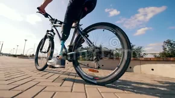 一个有仿生腿的人在户外骑自行车视频的预览图