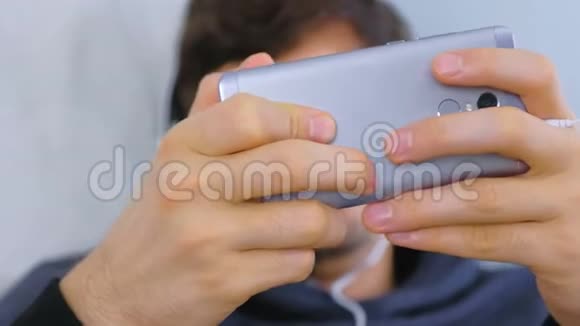 在智能手机里玩游戏的人双手特写视频的预览图