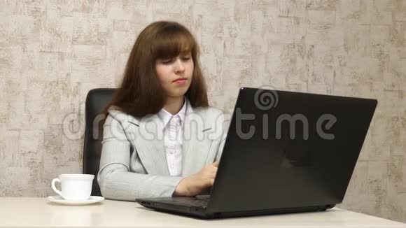 工作场所的一位年轻女商人在电脑上进行商务通信这个女孩在办公室工作视频的预览图