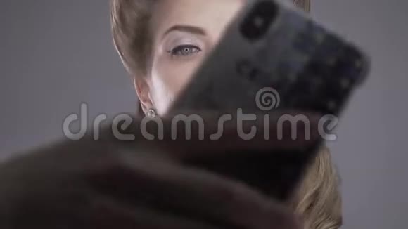蓝眼睛复古发型的金发女人正在自拍视频的预览图