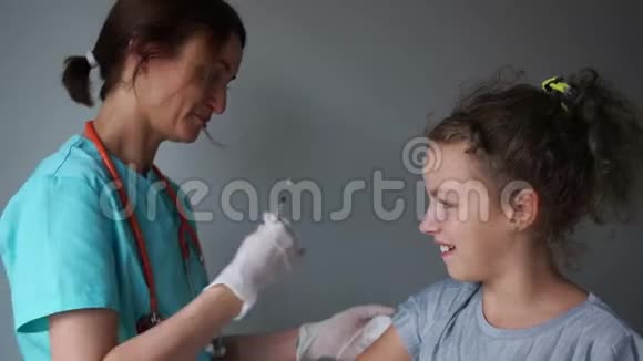 穿着医疗服的护士给一个医疗室的十几岁的女孩注射流感疫苗流感疫苗和医疗操纵视频的预览图
