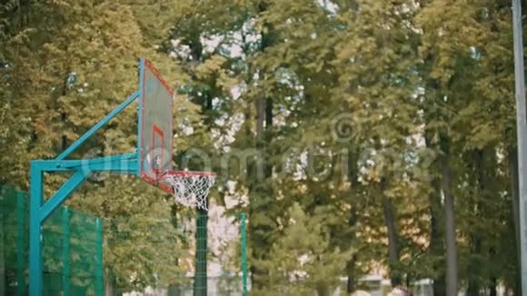 在外面的篮球训练一个年轻人跳着扔着一个球它就进入了目标视频的预览图
