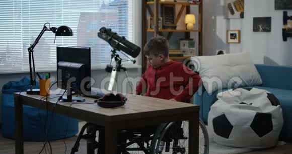 一个残疾男孩在电脑上聊天视频的预览图